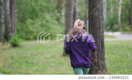 Portrait of young sportswoman jogging during outdoor training in park in the morning. Sport and healthy lifestyle concept 139962031