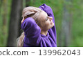 Blonde in purple sweatshirt doing morning exercises, breathing fresh air in forest 139962043