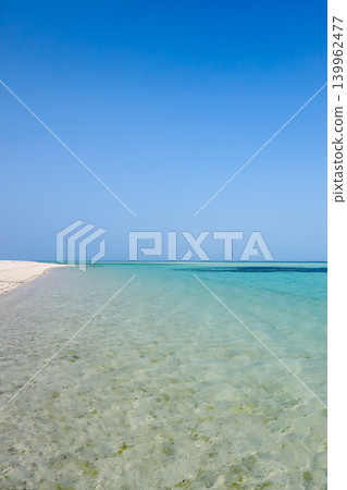 Blue sky and emerald green sea stretching out above_vertical 139962477