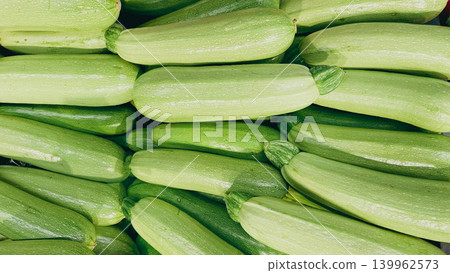 Full frame background of fresh ripe green zucchini on display at a supermarket grocery counter Full frame background of fresh ripe green zucchini on display at a supermarket grocery counter 139962573