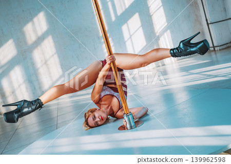 Young woman pole dancer in white interior at sunny day Young woman pole dancer in white interior at sunny day 139962598