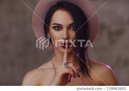 Portrait of young brunette woman in hat showing hush and silence Portrait of young brunette woman in hat showing hush and silence 139962605