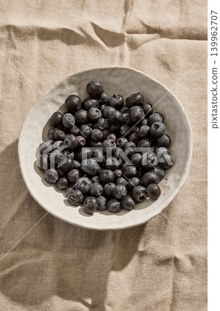 Fresh Blueberries in a Ceramic Bowl on a Linen Tablecloth. Top View Fresh Blueberries in a Ceramic Bowl on a Linen Tablecloth. Top View 139962707