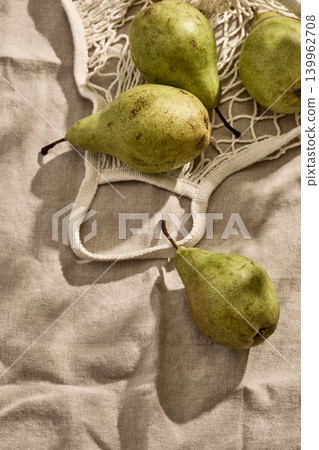 Fresh Italian pears in an Eco-Friendly Mesh Bag on a Linen Tablecloth. Top View 139962708