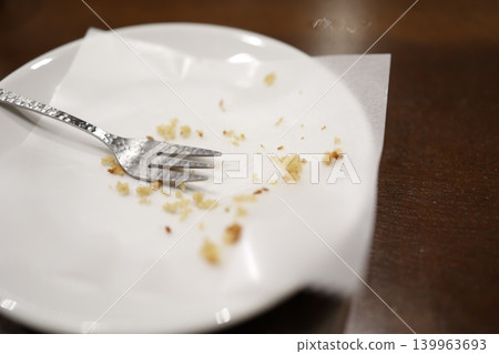 一把叉子和一些食物殘渣。白色盤子裡放著剩下的零食。 一把叉子和一些食物殘渣。白色盤子裡放著剩下的零食。 139963693