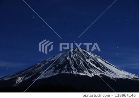Illuminated by the bright moon, Mount Fuji, a World Heritage Site, shines brilliantly in the nocturnal universe, displaying its majestic presence in the depths of winter. 139964146