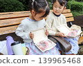 姊妹倆在公園長椅上吃甜甜圈 139965468