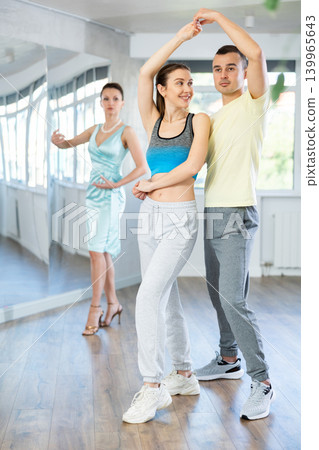 Smiling woman enjoying merengue with man in latin dance class 139965643