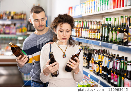 Couple man and woman choosing beer in store 139965645