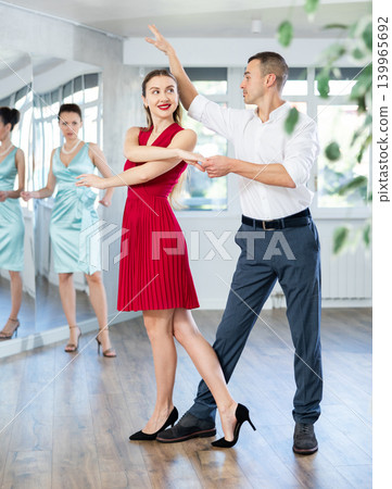 Couple in stage costumes learns waltz dancing during individual lesson 139965692