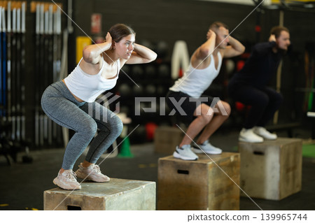 Girl jumping up on box during cross training at gym 139965744