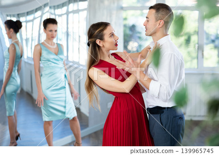 Couple in stage costumes learns tango dancing during individual lesson Couple in stage costumes learns tango dancing during individual lesson 139965745