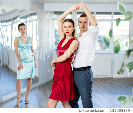 Couple in stage costumes learns waltz dancing during individual lesson 139965889