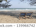 Beach chairs are placed on the sand by the sea. 139966742