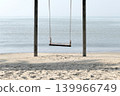 A wooden hanging swing on the beach by the sea. 139966749