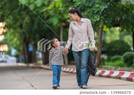mother holding daughter's hand and walking together to school. First day of education. 139966878