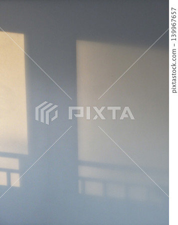 It is a white wall with sunlight and shadows. It is a white wall with sunlight and shadows. 139967657