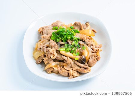 A photo of a Japanese-style stir-fry dish of pork and mushrooms topped with green onions. A photo of a Japanese-style stir-fry dish of pork and mushrooms topped with green onions. 139967806