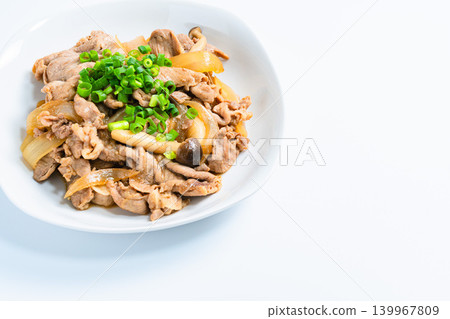 A photo of a Japanese-style stir-fry dish of pork and mushrooms topped with green onions. A photo of a Japanese-style stir-fry dish of pork and mushrooms topped with green onions. 139967809