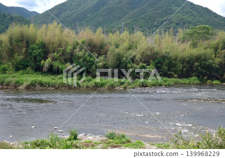 A natural landscape of early summer, with lush green mountains and a clear stream. A natural landscape of early summer, with lush green mountains and a clear stream. 139968229