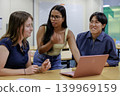 Office scene of young men and women working on laptops. 139969159