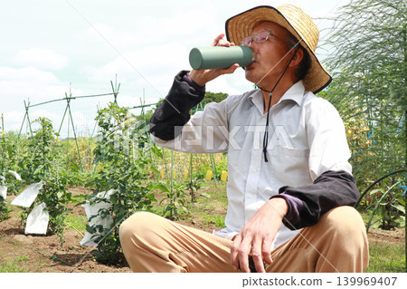 Senior man hydrating in the field Senior man hydrating in the field 139969407