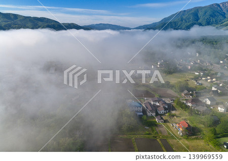透過長野縣白馬村壯麗的雲海,可以看到白馬的城鎮景觀(無人機空拍照片)。 透過長野縣白馬村壯麗的雲海,可以看到白馬的城鎮景觀(無人機空拍照片)。 139969559