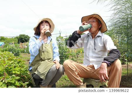 Senior couple hydrating in the field Senior couple hydrating in the field 139969622