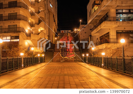 Nikko City, Tochigi Prefecture: Kinugawa Onsen Fureai Bridge and Kinuta Staircase Art illuminated by orange streetlights at night. Nikko City, Tochigi Prefecture: Kinugawa Onsen Fureai Bridge and Kinuta Staircase Art illuminated by orange streetlights at night. 139970072