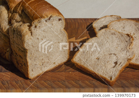 It is a slice of bread placed on a wooden cutting board. It is a slice of bread placed on a wooden cutting board. 139970173