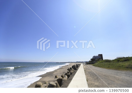 A sandy beach lined with Western-style houses and tetrapods along the coast. A sandy beach lined with Western-style houses and tetrapods along the coast. 139970500