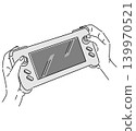 A monochrome illustration of a hand holding a portable game console. 139970521