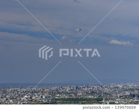 一架客機從伊丹機場起飛，飛越市區。 139970889