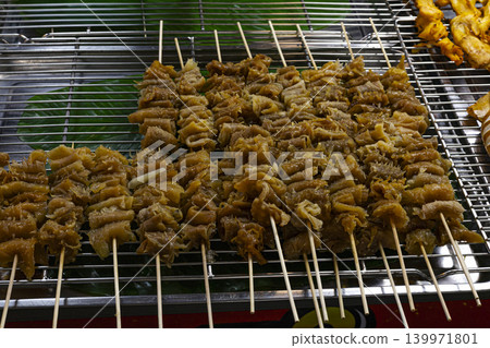 Marinated Squid Skewers On Grill Rack, A mouthwatering photo of marinated squid skewers sizzling on a grill rack, capturing bold smoky flavors, perfect for food documentary and culinary advertising. Marinated Squid Skewers On Grill Rack, A mouthwatering photo of marinated squid skewers sizzling on a grill rack, capturing bold smoky flavors, perfect for food documentary and culinary advertising. 139971801
