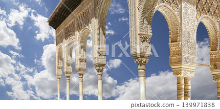 Arches in Islamic (Moorish) style (against the background of a beautiful sky with clouds) in Alhambra, Granada, Spain Arches in Islamic (Moorish) style (against the background of a beautiful sky with clouds) in Alhambra, Granada, Spain 139971838