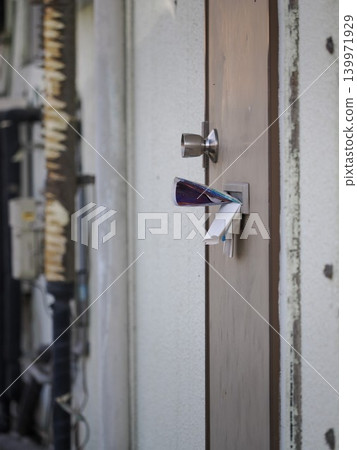 The front door of an apartment building overflowing with flyers that have been delivered to the door. The front door of an apartment building overflowing with flyers that have been delivered to the door. 139971929