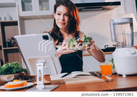 Woman preparing green smoothie in bright kitchen with fresh fruits and vegetables, healthy eating lifestyle moment in natural daylight Woman preparing green smoothie in bright kitchen with fresh fruits and vegetables, healthy eating lifestyle moment in natural daylight 139971961
