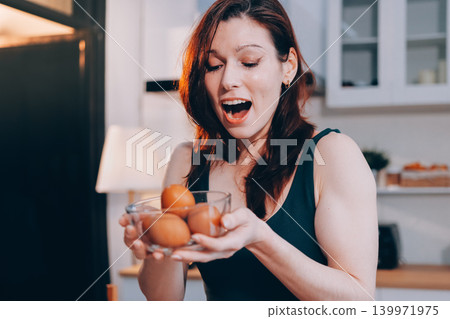 Woman preparing green smoothie in bright kitchen with fresh fruits and vegetables, healthy eating lifestyle moment in natural daylight Woman preparing green smoothie in bright kitchen with fresh fruits and vegetables, healthy eating lifestyle moment in natural daylight 139971975