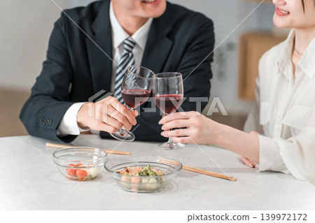 一對情侶舉杯紅酒,雙手相碰。 一對情侶舉杯紅酒,雙手相碰。 139972172