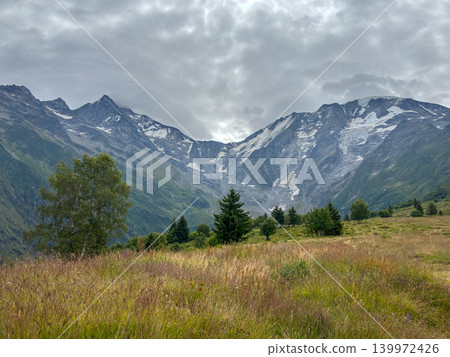 Alpine pasture under cloudy sky in Les Contamines-Montjoie, France Alpine pasture under cloudy sky in Les Contamines-Montjoie, France 139972426