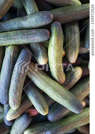 Pile Of Fresh Green Cucumbers At The Market, A photo of fresh green cucumbers at the market, cucumbers stacked neatly with water droplets, perfect for fresh produce or local market documentary. Pile Of Fresh Green Cucumbers At The Market, A photo of fresh green cucumbers at the market, cucumbers stacked neatly with water droplets, perfect for fresh produce or local market documentary. 139972626