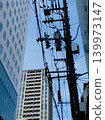 電線桿和電線與城市的摩天大樓錯綜複雜地交織在一起。 139973147