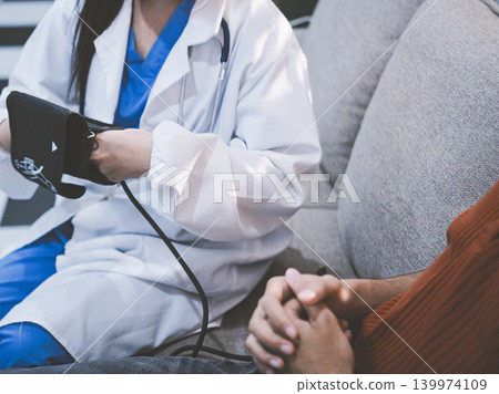 Doctor checks patient's blood pressure with cuff and stethoscope in a medical Doctor checks patient's blood pressure with cuff and stethoscope in a medical 139974109