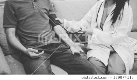 Doctor checks patient's blood pressure with cuff and stethoscope in a medical 139974113