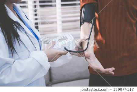 Doctor checks patient's blood pressure with cuff and stethoscope in a medical Doctor checks patient's blood pressure with cuff and stethoscope in a medical 139974117