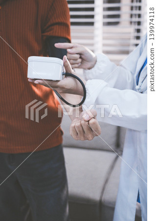 Doctor checks patient's blood pressure with cuff and stethoscope in a medical 139974118
