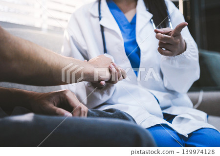 A doctor is holding hands with an elderly patient. A doctor is holding hands with an elderly patient. 139974128