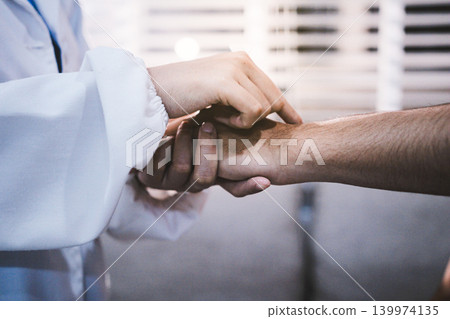 A doctor is holding hands with an elderly patient. A doctor is holding hands with an elderly patient. 139974135