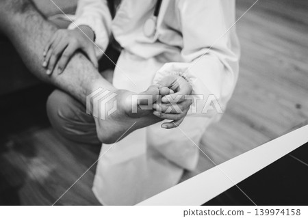 Female doctor examining male patient leg in hospital Female doctor examining male patient leg in hospital 139974158