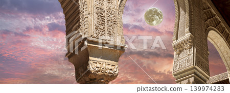 Arches in Islamic (Moorish) style (against the sunset with the super moon) in Alhambra, Granada, Spain Arches in Islamic (Moorish) style (against the sunset with the super moon) in Alhambra, Granada, Spain 139974283